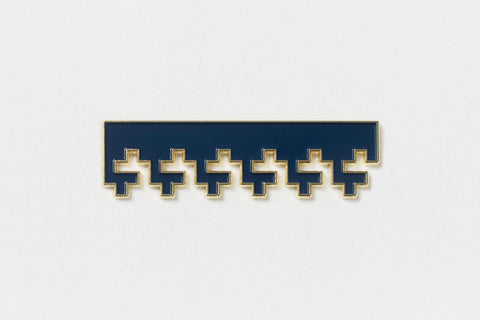 a rectangular blue pin with gold edges and Greek key designs descending