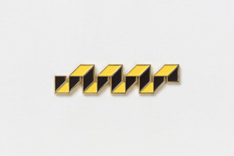 A black and yellow rectangular pin in the shape of a fret
