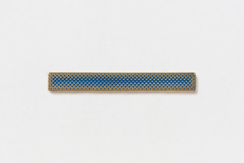 A long rectangular gold pin with a central blue gradient 