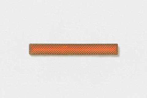A long rectangular gold pin with a central orange gradient