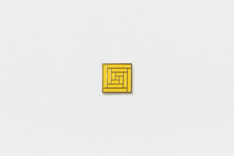 A square yellow pin with gold edges throughout a geometric vortex