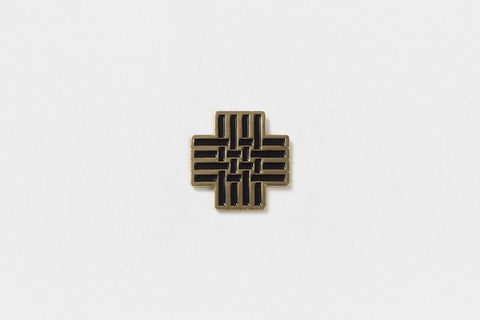 A square pin with a black hashtag and gold edges
