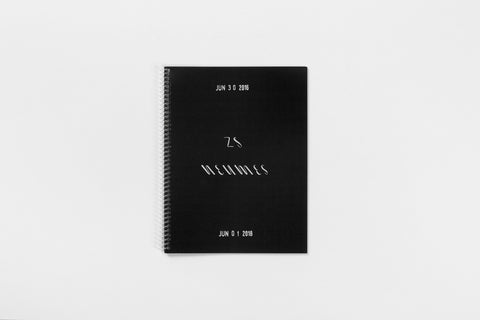 Black book with clear spiral binding and white text on the cover